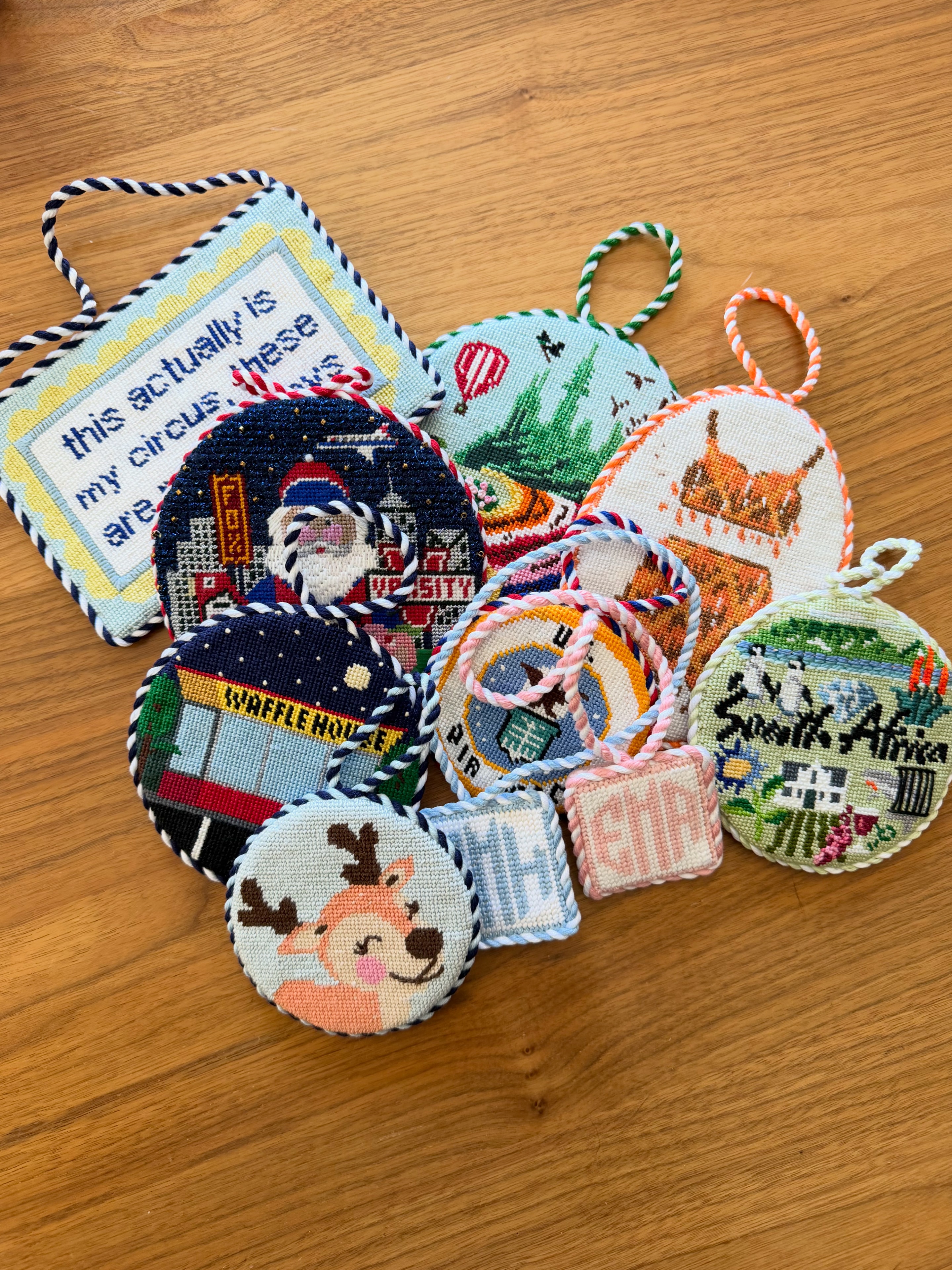 Finished needlepoint ornaments on wooden surface